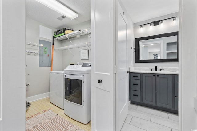 laundry area featuring washer and dryer, sink, a textured ceiling, and electric panel