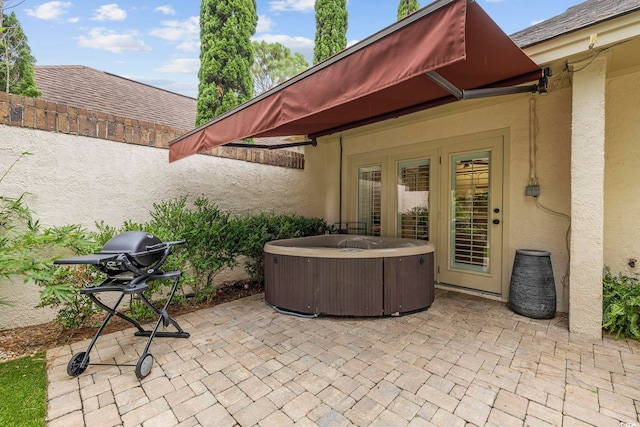 view of patio / terrace featuring a hot tub and grilling area