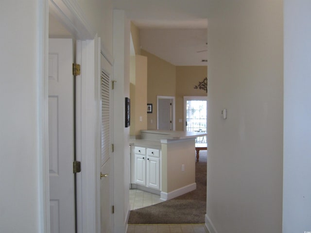 hall featuring light carpet and baseboards