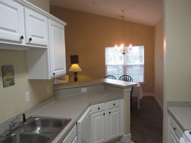 kitchen with white cabinetry, vaulted ceiling, white dishwasher, a sink, and a peninsula