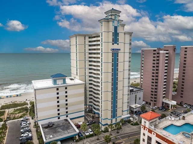 view of building exterior featuring a water view and a city view