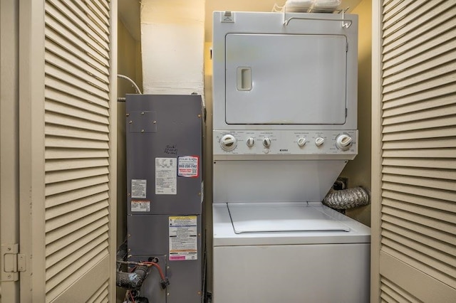 clothes washing area with stacked washing maching and dryer