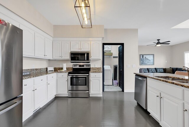 kitchen with sink, dark stone countertops, white cabinetry, and stainless steel appliances