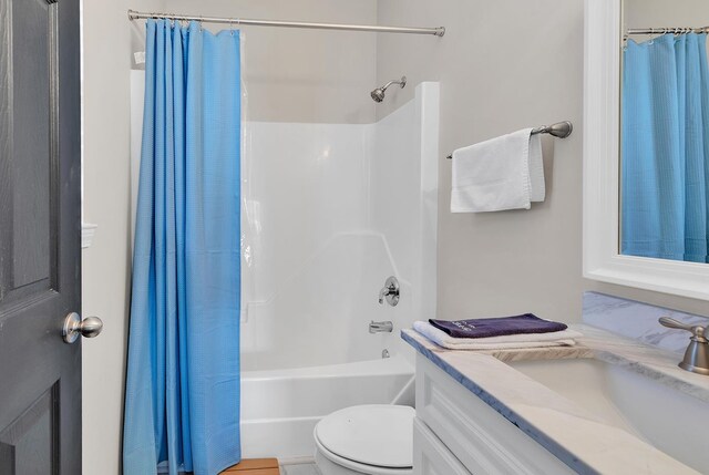 full bathroom featuring vanity, shower / bath combo with shower curtain, and toilet