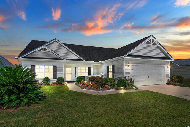 view of front facade with a yard, a garage, and a porch