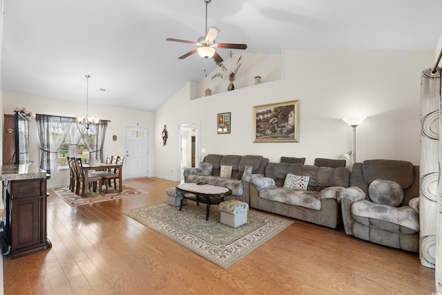 living room featuring ceiling fan with notable chandelier, high vaulted ceiling, and light hardwood / wood-style flooring