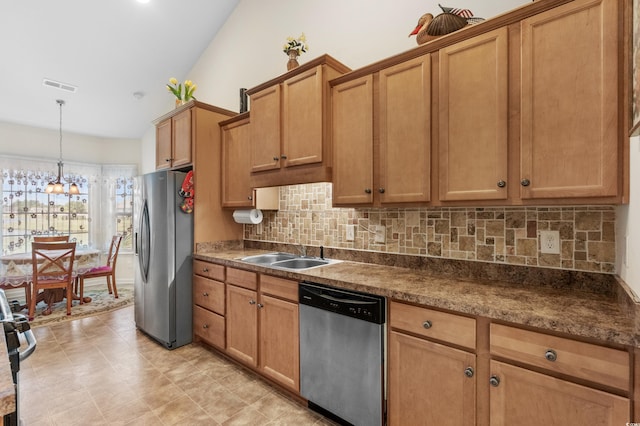 kitchen with vaulted ceiling, pendant lighting, a notable chandelier, appliances with stainless steel finishes, and sink