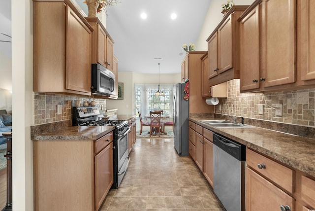 kitchen with hanging light fixtures, sink, appliances with stainless steel finishes, and decorative backsplash