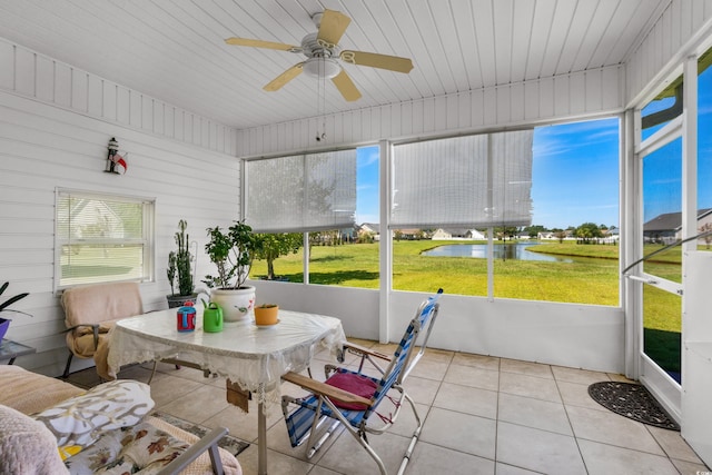 sunroom / solarium featuring a water view and ceiling fan