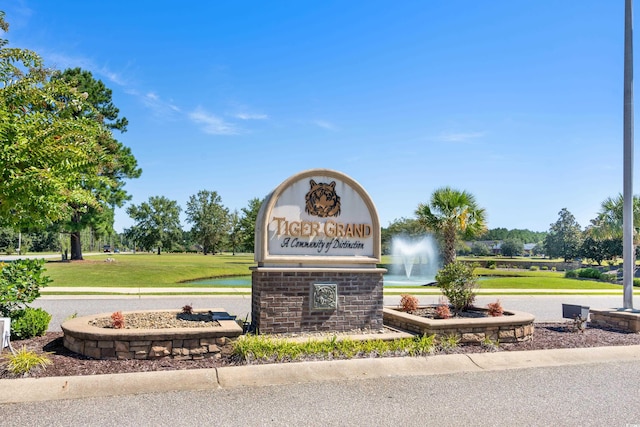 community sign featuring a lawn