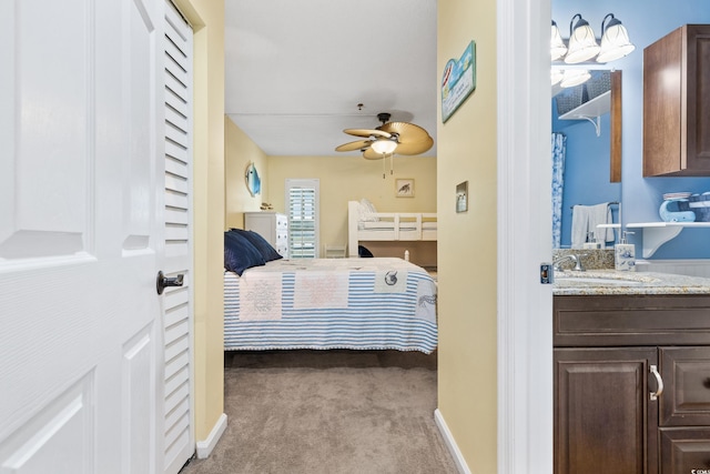 carpeted bedroom with ceiling fan and sink