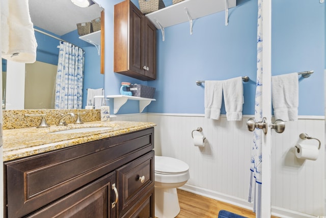 bathroom with wood-type flooring, vanity, and toilet