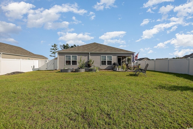 rear view of property featuring a yard