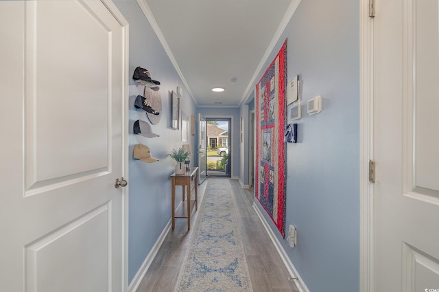 hallway with wood-type flooring and crown molding