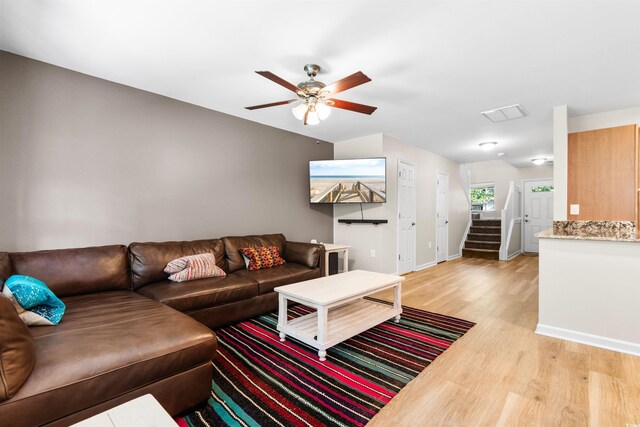 living room featuring ceiling fan and light hardwood / wood-style floors