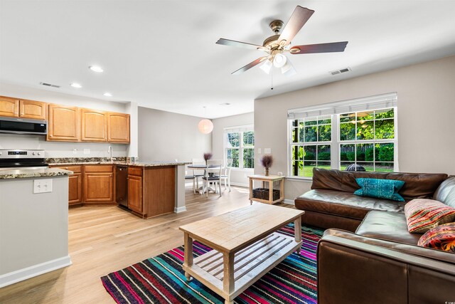 living room featuring light hardwood / wood-style flooring and ceiling fan