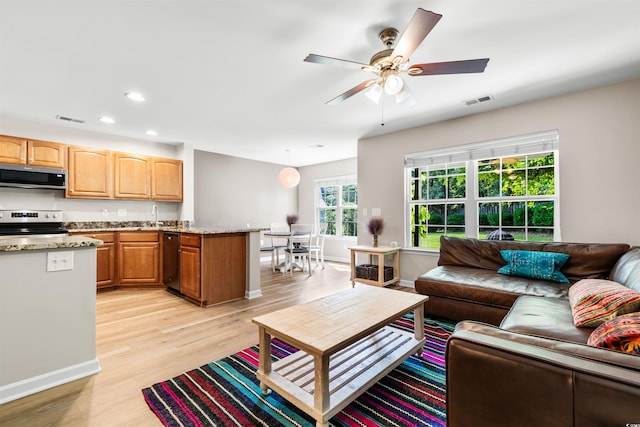 living area with recessed lighting, baseboards, visible vents, and light wood finished floors