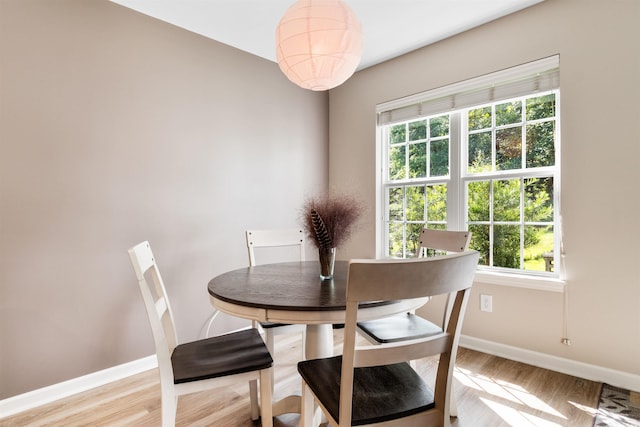 dining space with light wood-style flooring and baseboards