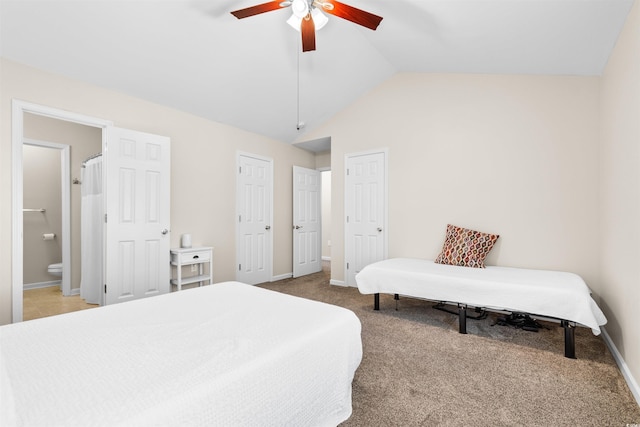 bedroom featuring lofted ceiling, ceiling fan, ensuite bathroom, baseboards, and carpet