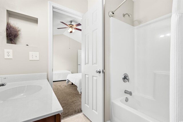 bathroom featuring tile patterned floors, vaulted ceiling, bathing tub / shower combination, vanity, and ceiling fan