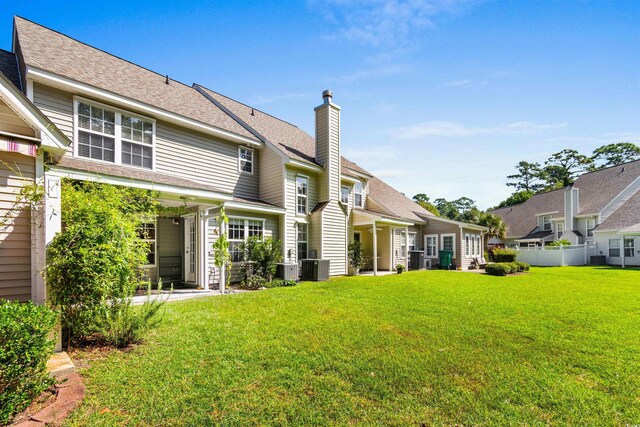 back of house featuring a lawn and cooling unit