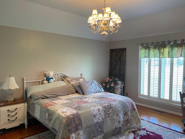 bedroom with a chandelier and dark hardwood / wood-style flooring