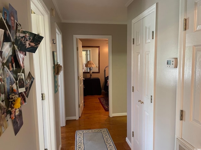 hallway with hardwood / wood-style flooring and crown molding