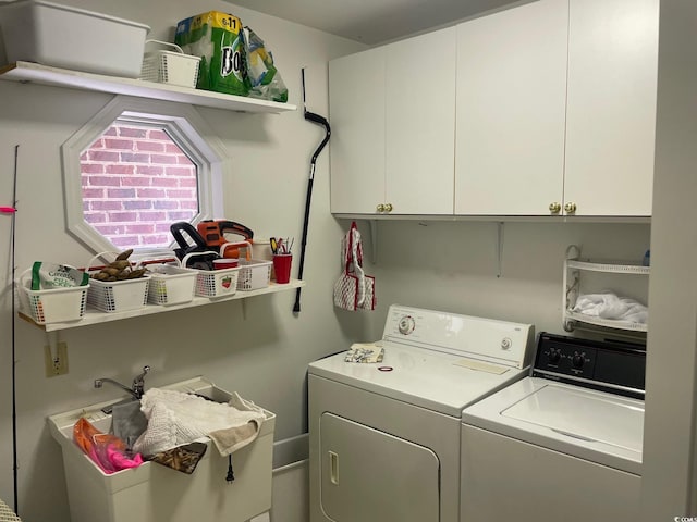 clothes washing area with cabinets and washer and clothes dryer