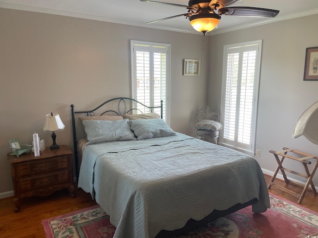 bedroom featuring ceiling fan, crown molding, and dark hardwood / wood-style flooring