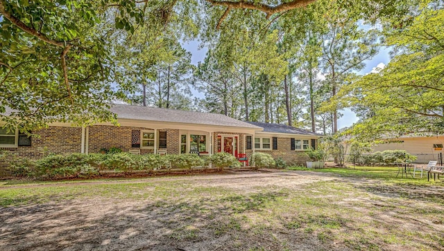 single story home featuring a front yard and brick siding