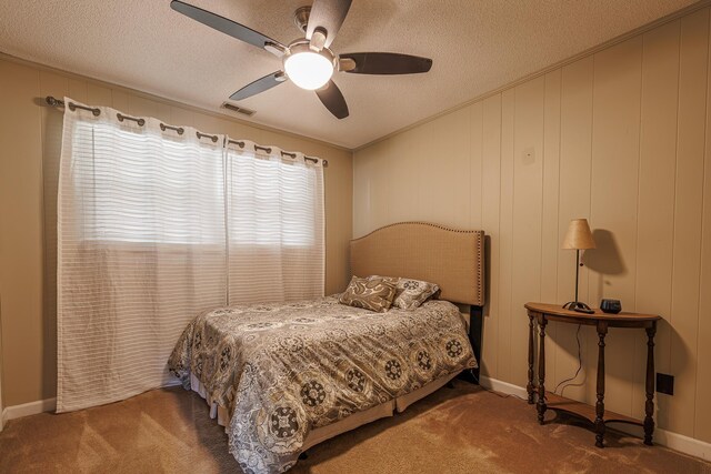 carpeted bedroom with ceiling fan and a textured ceiling