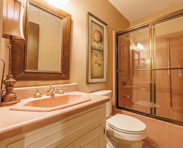 full bathroom featuring enclosed tub / shower combo, a textured ceiling, vanity, and toilet