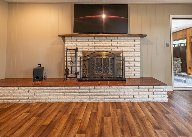 interior details featuring a brick fireplace and wood finished floors