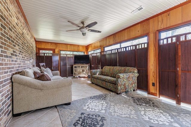 living area with plenty of natural light, brick wall, and visible vents