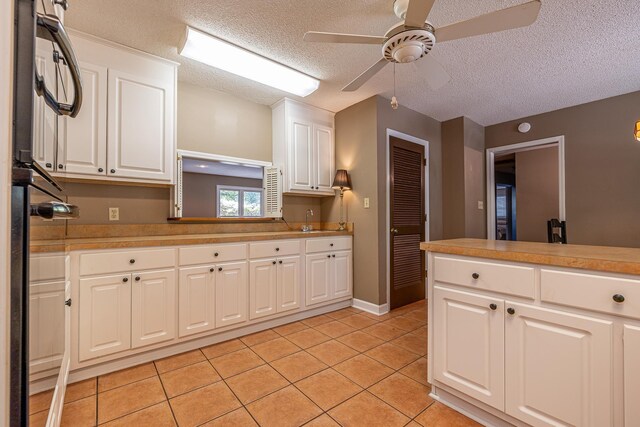 kitchen featuring light tile patterned flooring, sink, a textured ceiling, ceiling fan, and white cabinets