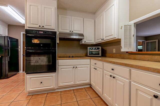 kitchen with white cabinets, a textured ceiling, black appliances, and light tile patterned floors