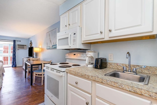 kitchen with sink, white appliances, dark wood-type flooring, white cabinetry, and a wall mounted air conditioner