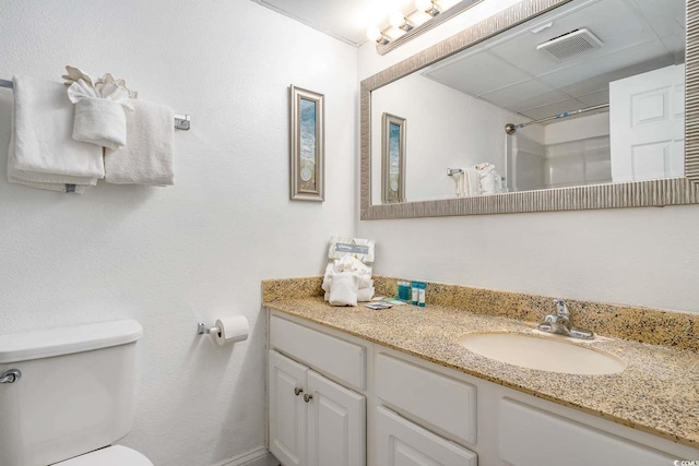 bathroom with vanity, toilet, and a shower