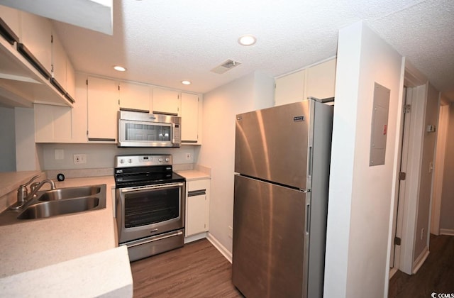 kitchen featuring dark hardwood / wood-style floors, a textured ceiling, sink, and stainless steel appliances