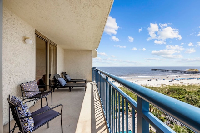 balcony featuring a beach view and a water view