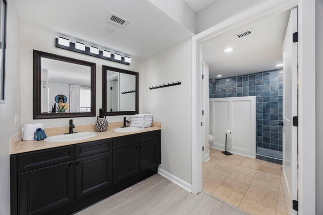 bathroom with tile patterned floors, dual vanity, and toilet