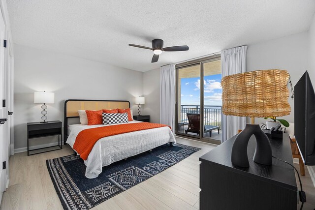 bedroom with light hardwood / wood-style floors, a textured ceiling, access to outside, ceiling fan, and floor to ceiling windows