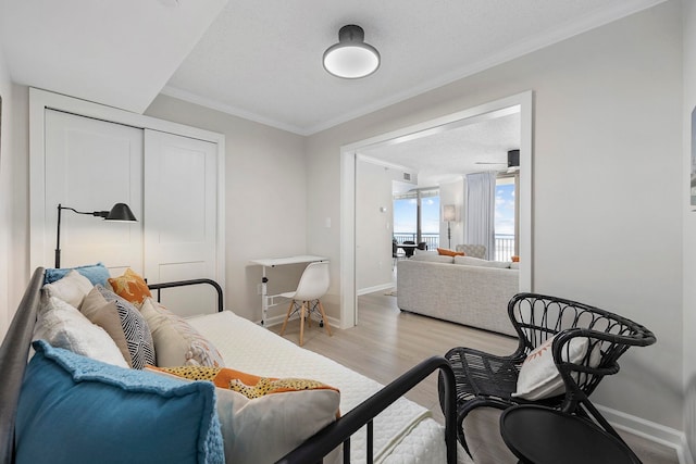 living room featuring a textured ceiling, light hardwood / wood-style flooring, and crown molding