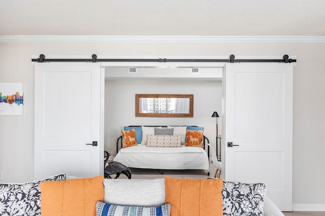 bedroom featuring ornamental molding and a barn door