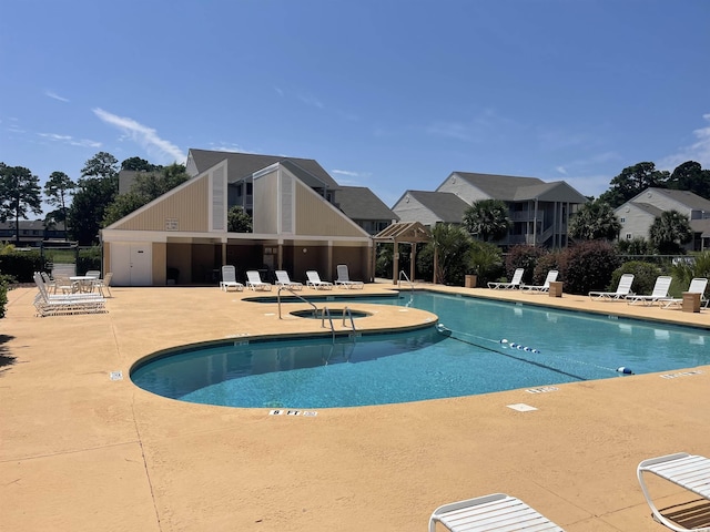 community pool with a patio area and fence