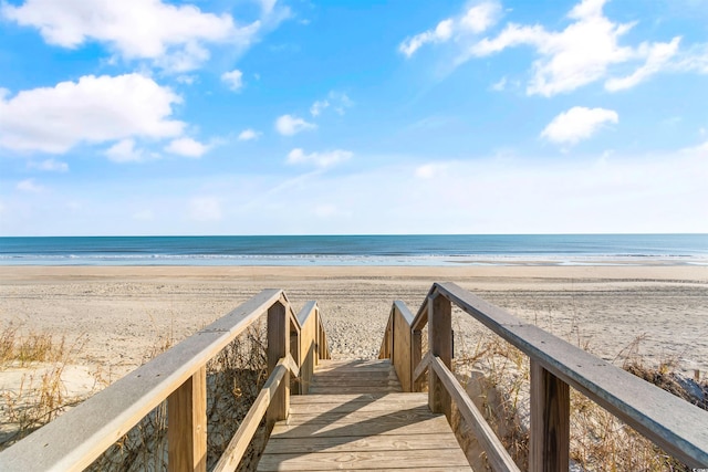 view of property's community with a beach view and a water view