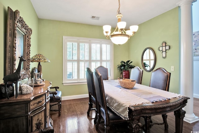 dining area with decorative columns, dark wood-type flooring, and an inviting chandelier