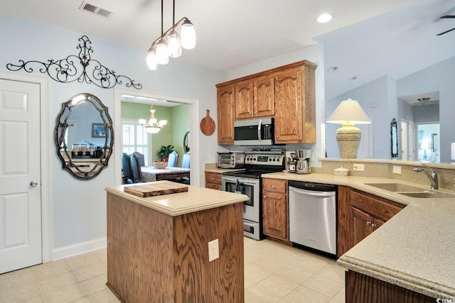 kitchen with pendant lighting, appliances with stainless steel finishes, light tile patterned floors, sink, and a notable chandelier