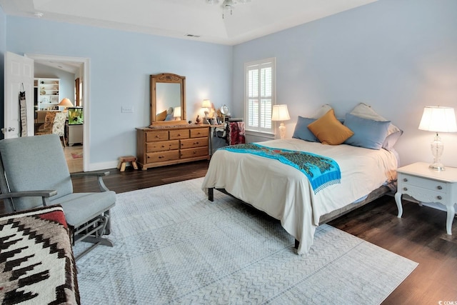 bedroom with dark hardwood / wood-style flooring