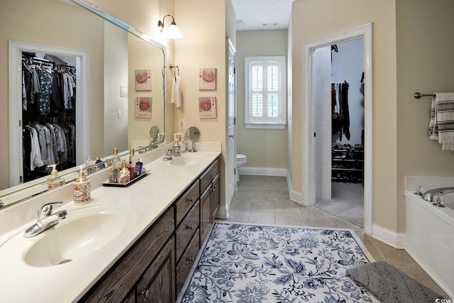 bathroom with tile patterned flooring, toilet, a bathing tub, and double sink vanity